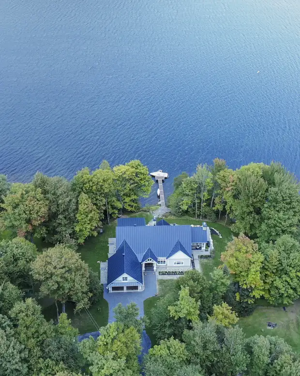 Vue aérienne d'une propriété au bord d'un lac, avec son quai privé