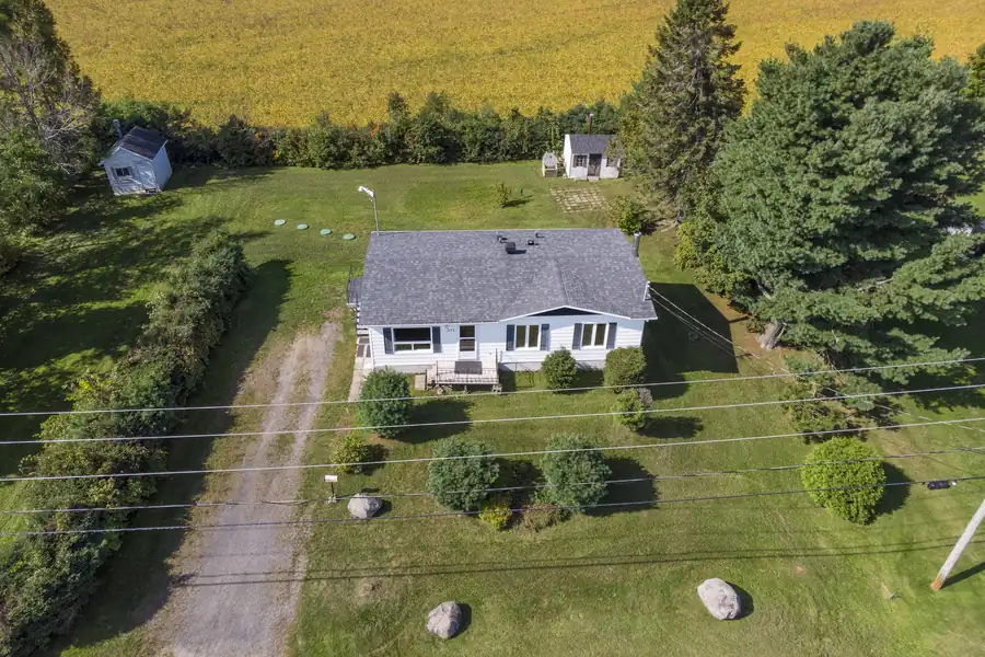 Vue aérienne d'une maison de campagne bordée de champs cultivés