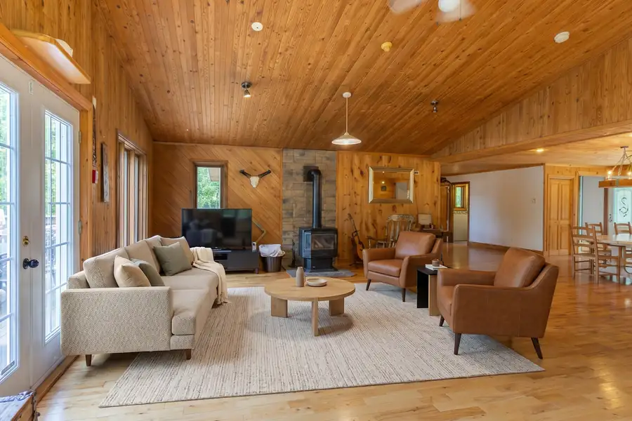 Salon de chalet avec plafond cathédrale en bois et poêle à bois